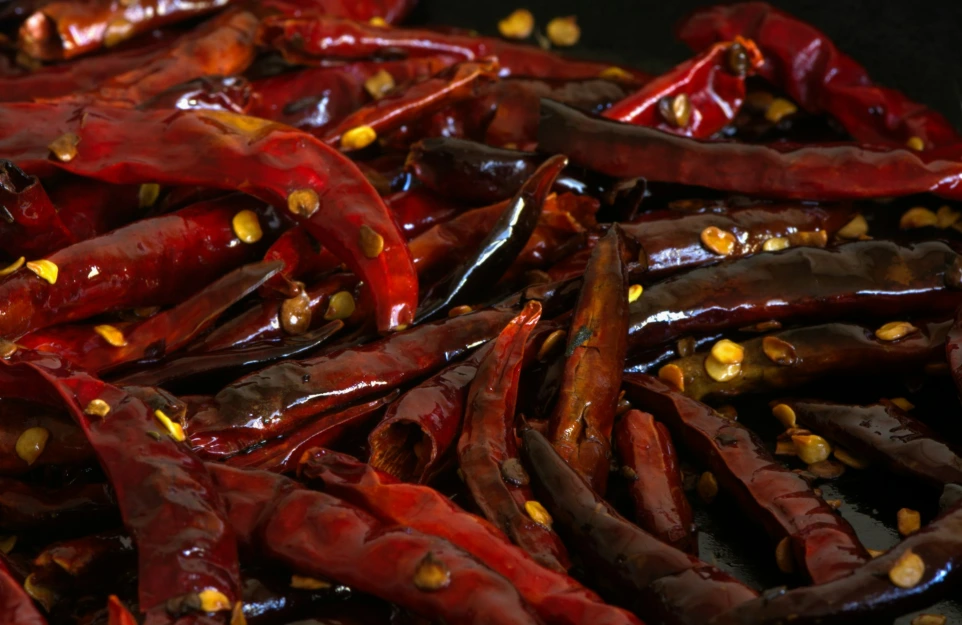 a pile of red peppers with yellow seeds